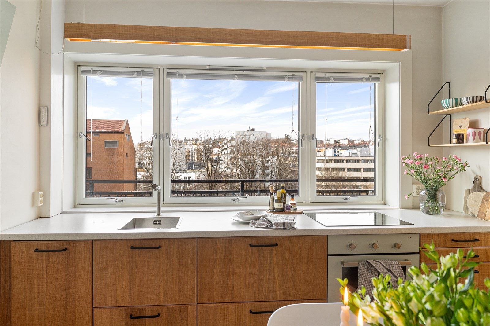 Benkeplaten i laminat gir gode arbeidsflater, og kjøkkenet er innredet med integrerte hvitevarer og nedfelt oppvaskkum i rustfritt stål. Galleribilde