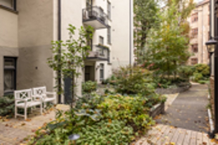 Veldig pent opparbeidet gårdsrom med beplantning, belegningsstein og sittegrupper. Galleribilde