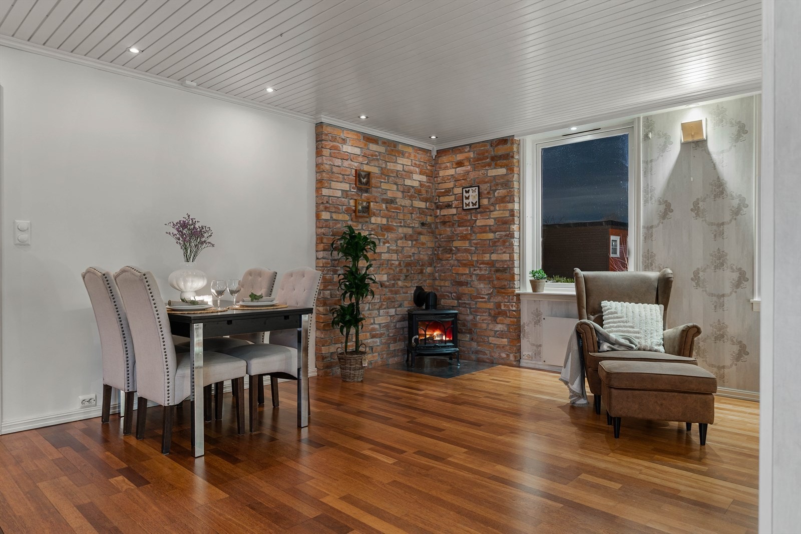 I stuen er det en nydelig teglsteinvegg med en sjarmerende vedovn som varmer godt på kalde vinterdager. Galleribilde