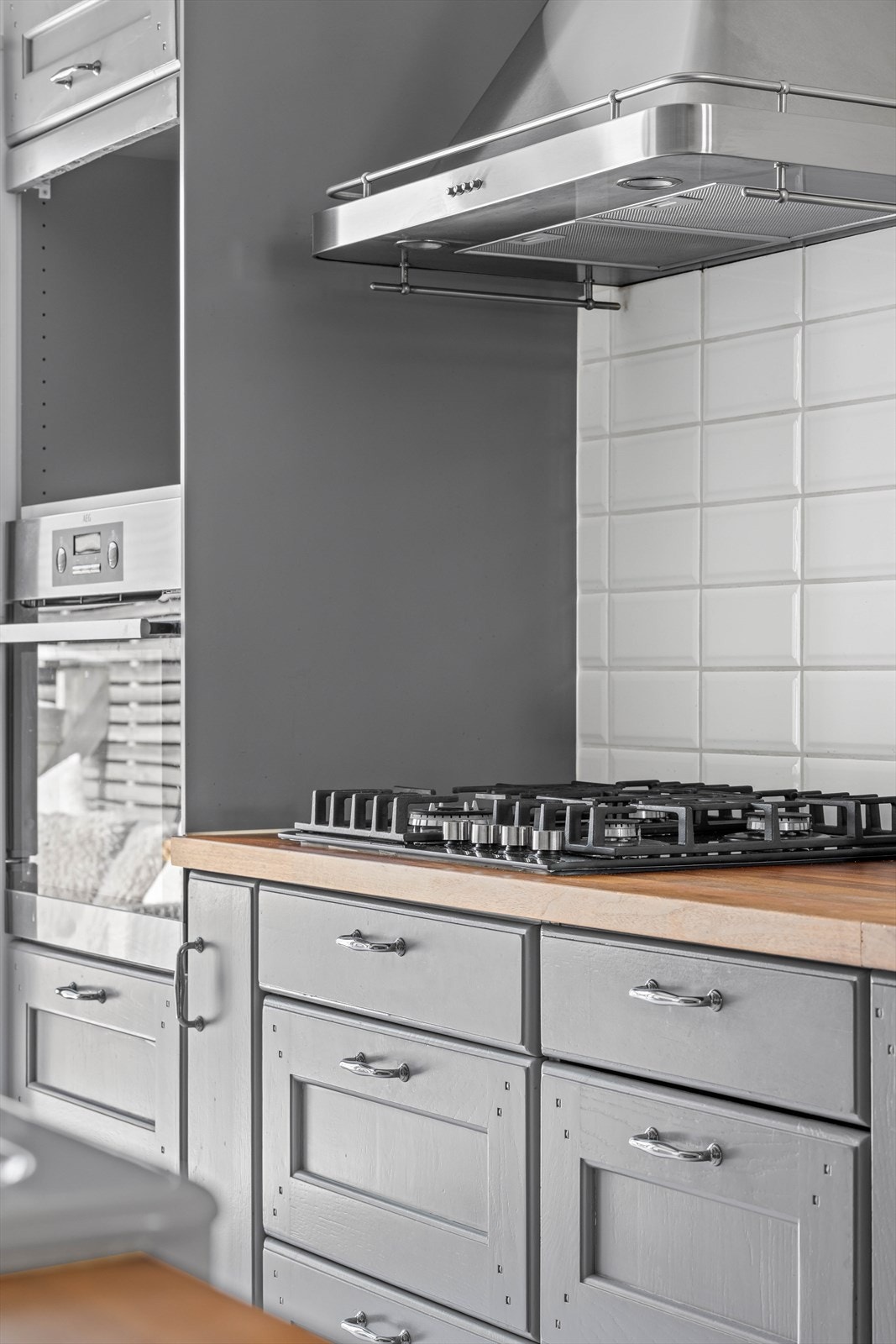 Kjøkkenet har en Ikeainnredning med grå, profilerte fronter med integrert koketopp. Galleribilde