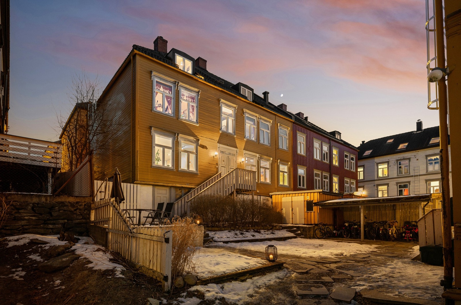 Hyggelig bakgård mellom de to byggene, hvor det er opparbeidet uteplass/platting, hellebelagt sti, et praktisk sykkelskur, felles bod og nedgang til kjeller med bodareal. Galleribilde