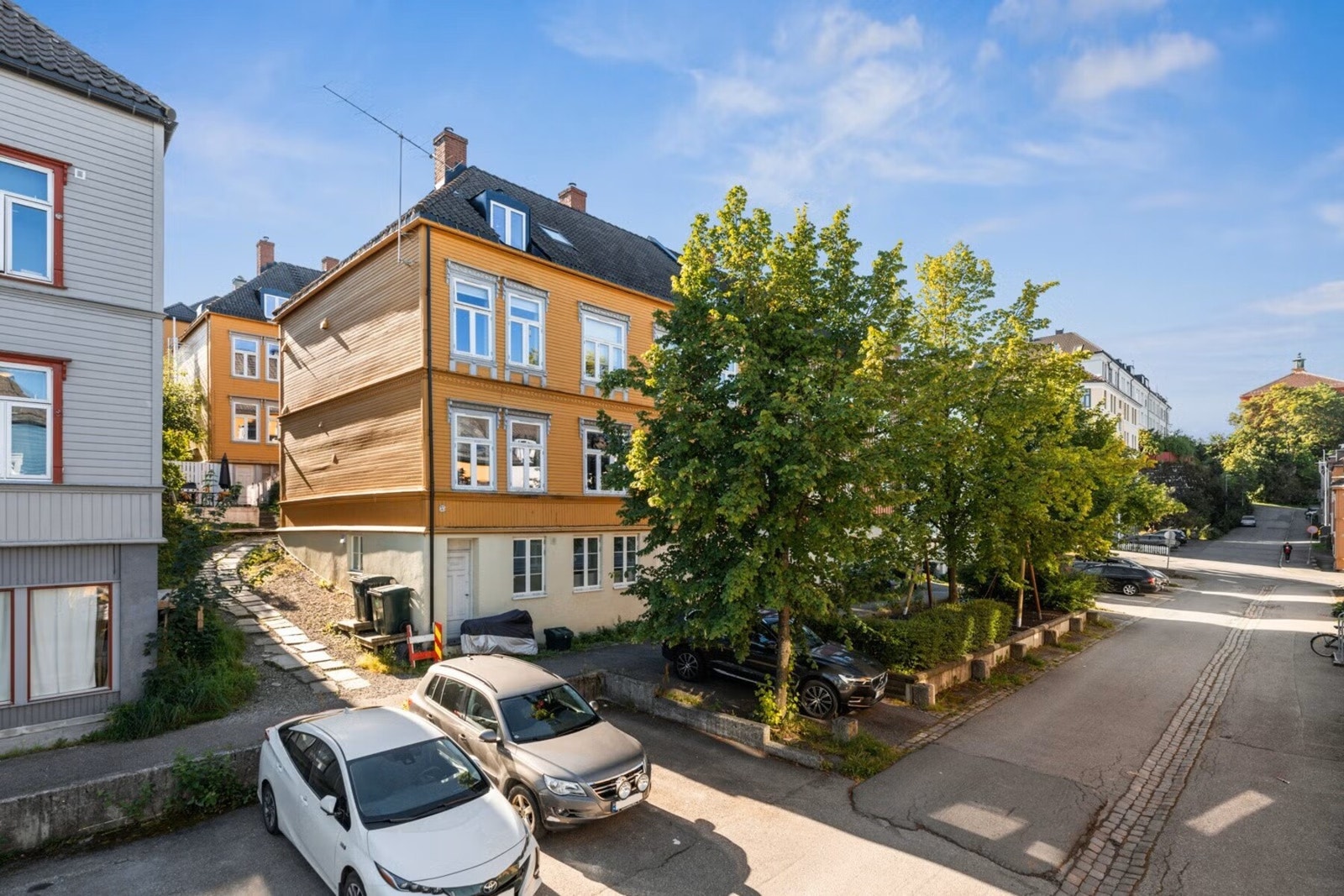 Leiligheten har en svært sentral, men samtidig tilbaketrukket beliggenhet på Øvre Møllenberg. Leiligheten ligger i det bakerste gule bygget - trukket lengst bort fra gaten. Soneparkering like utenfor. Foto: Joakim Reinaas. Galleribilde