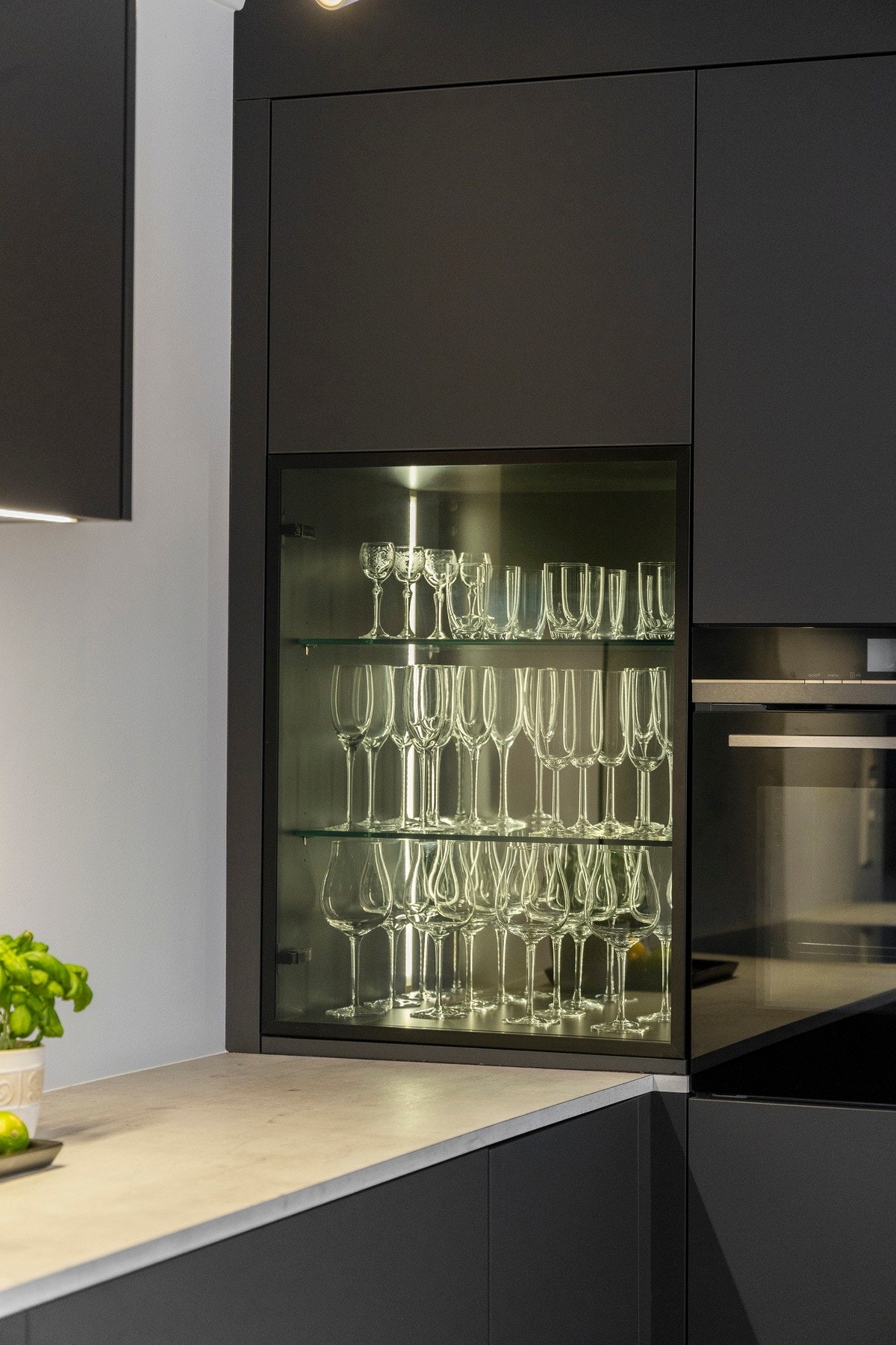 Stilrene glassdører med opplyste hyller gir kjøkkenet en stilig og eksklusiv detalj. Galleribilde