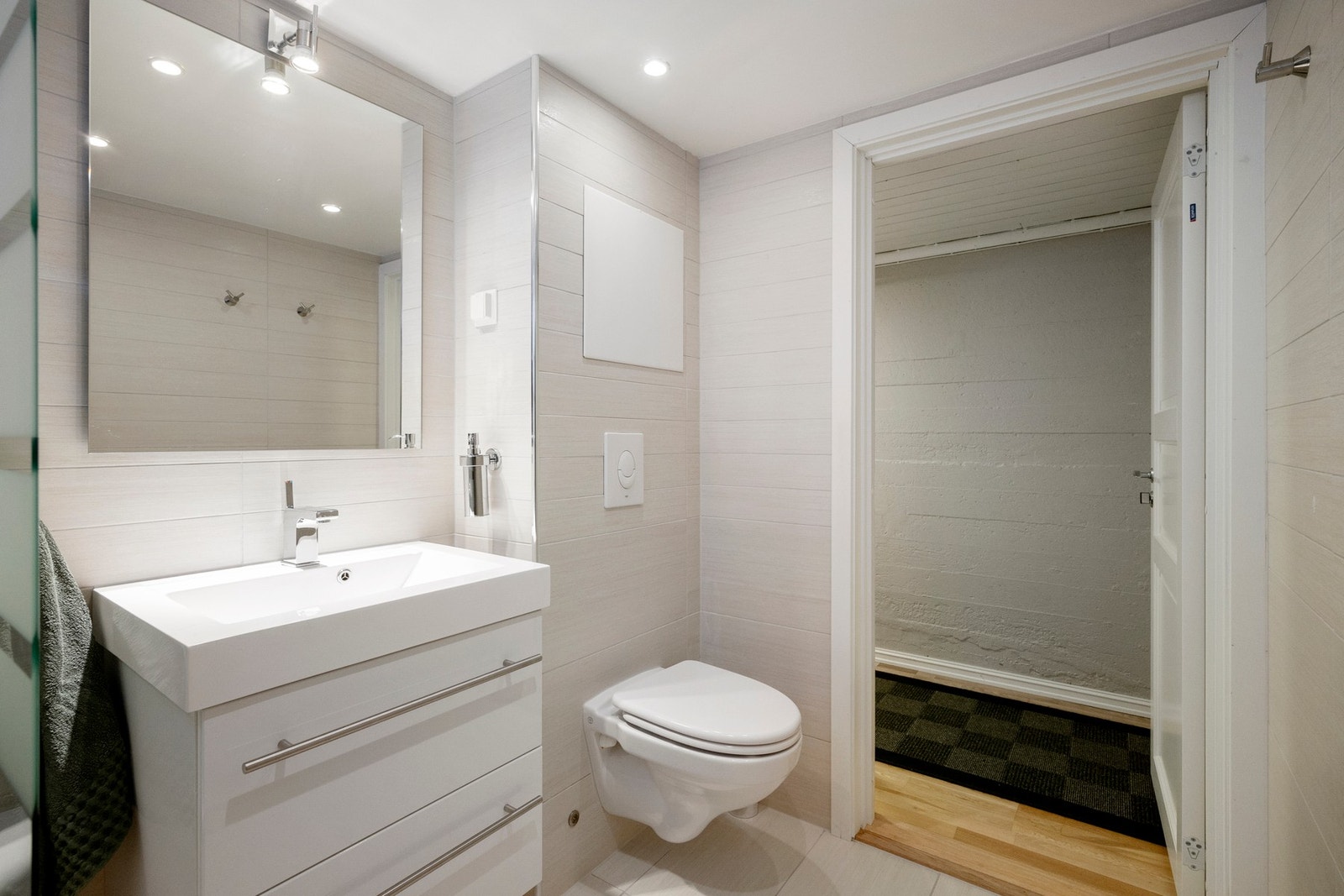 Badet er innredet med toalett, servantskap, speil og badekar. Galleribilde