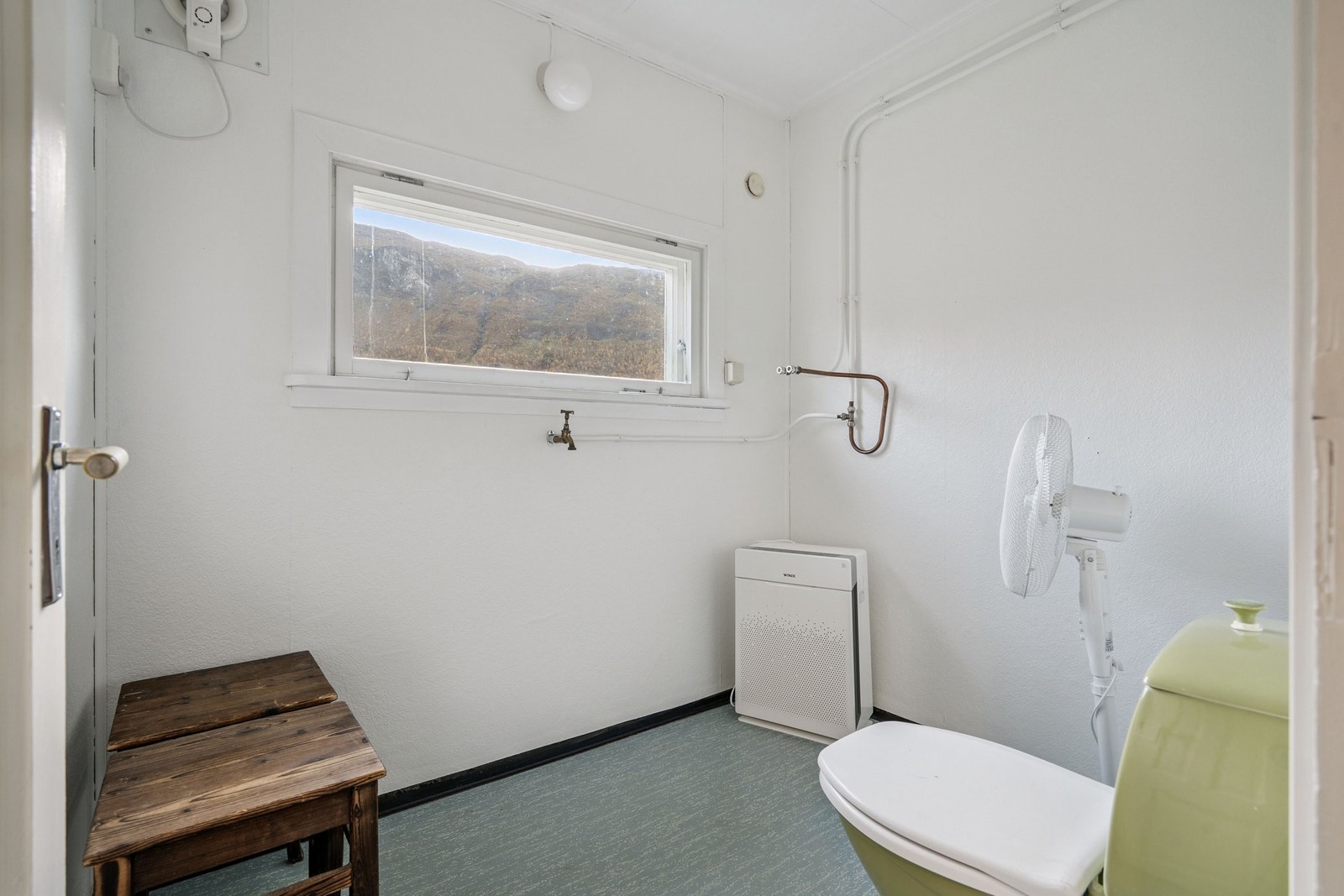 Lite vaskerom med plass til både vaskemaskin, tørketrommel, toalett og vaskeservant. Galleribilde