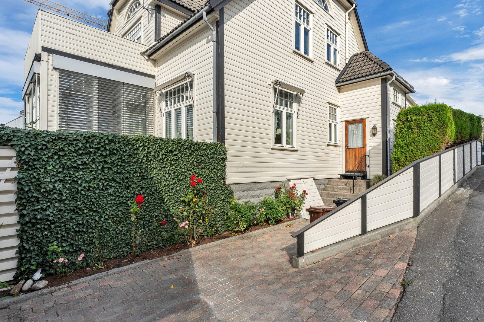 Steinlagt gårdsplass mellom garasje og bolig. Galleribilde