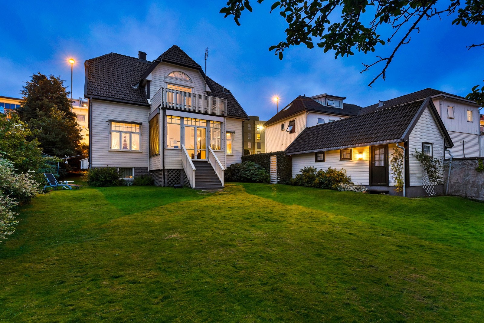 Vestvendt hage og fasade i kveldsstemning. Galleribilde