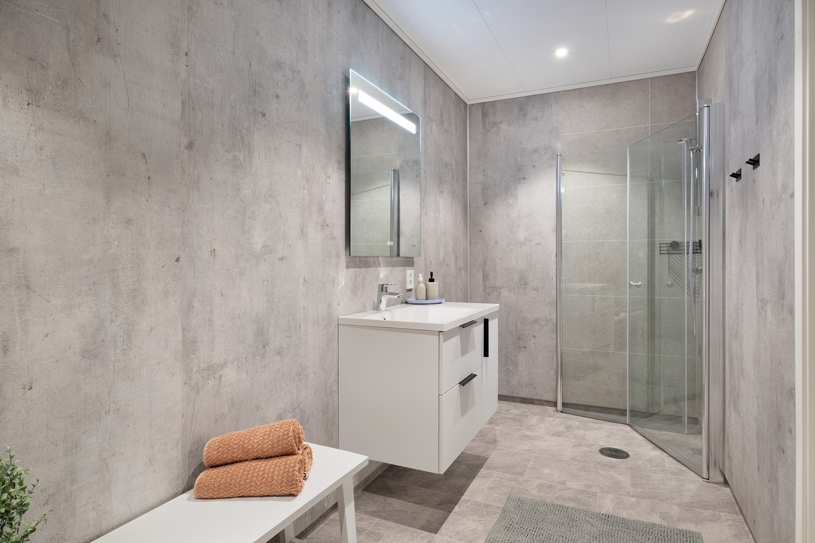 Fint bad i samme tidlause utførelse som i mellometasjen. Rommet har god belysning meg spottar i tak. Galleribilde