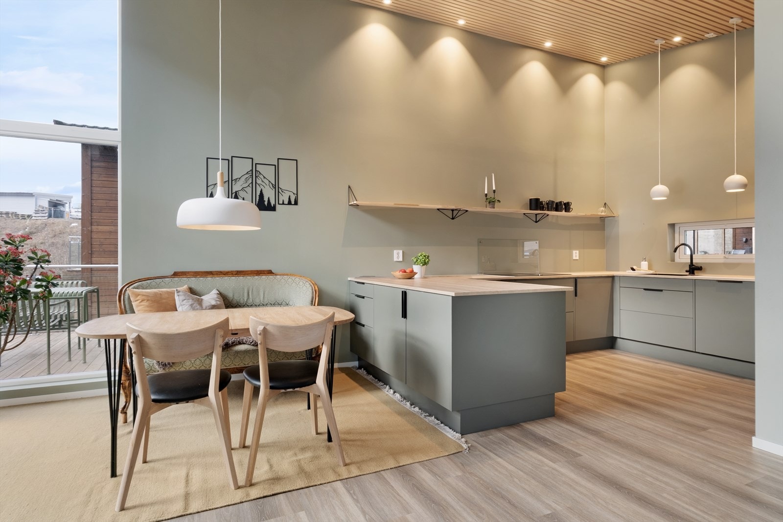 Lekkert kjøken i ein lun grøntone som skaper eit triveleg og moderne uttrykk. Himlinga har dekorative spiler med innfelte spottar som gir flott og stemningsfull belysning. Galleribilde