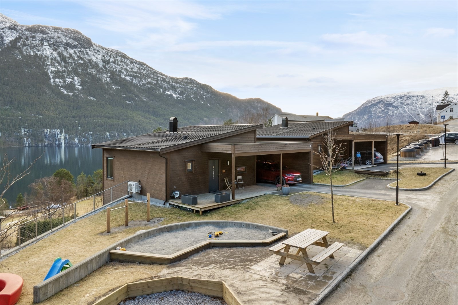 I asfaltert tun er det carport med parkering for ein bil samt ein utvendig parkeringsplass. Galleribilde