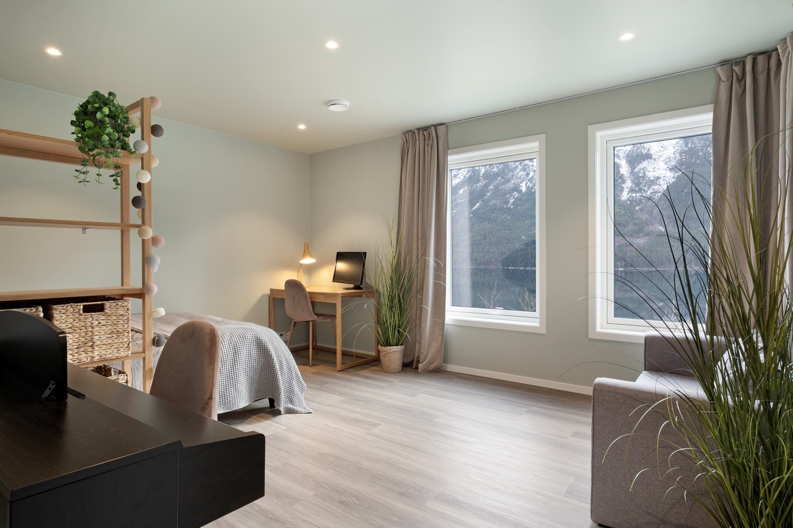 Soverom i underetasjen, måla i lune fargar med spottar i tak. Her er fleire møbleringsmuligheiter, enten ein vil bruke det som soverom eller eit ekstra opphaldsrom. Galleribilde