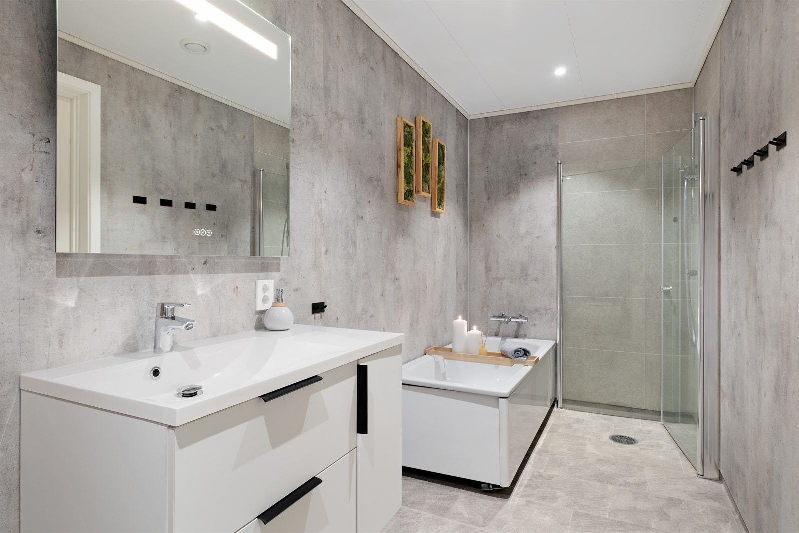 Badet er funksjonelt innreia med både badekar og dusjhjørne, servant og toalett. Rommet har god belysning med spottar i tak og lys i spegel. Galleribilde