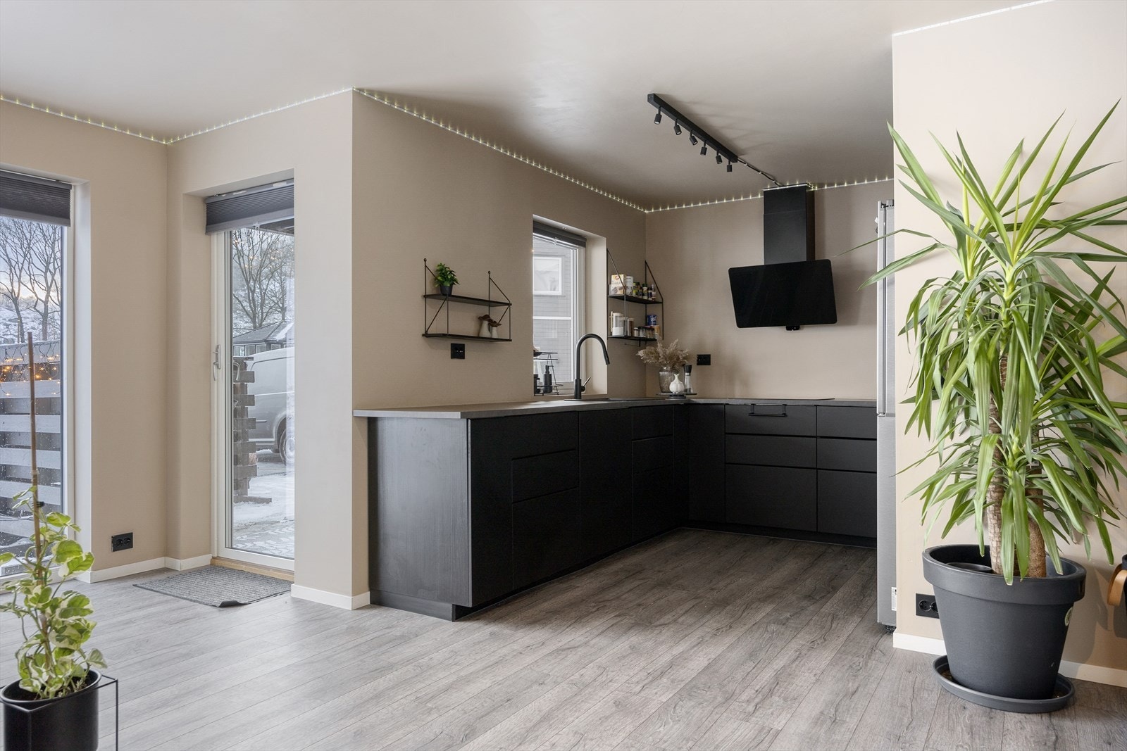 Kjøkkenet er moderne og stilrent med slette fronter og integrerte hvitevarer. Her har du rikelig med skap- og benkeplass, noe som gjør det enkelt å holde orden og tilberede mat i hverdagen. Galleribilde