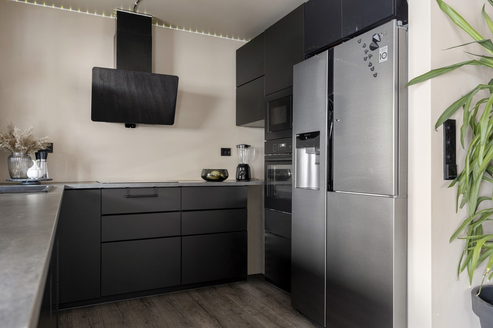 Kjøkkenet er moderne og stilrent med slette fronter og integrerte hvitevarer. Her har du rikelig med skap- og benkeplass, noe som gjør det enkelt å holde orden og tilberede mat i hverdagen. Galleribilde