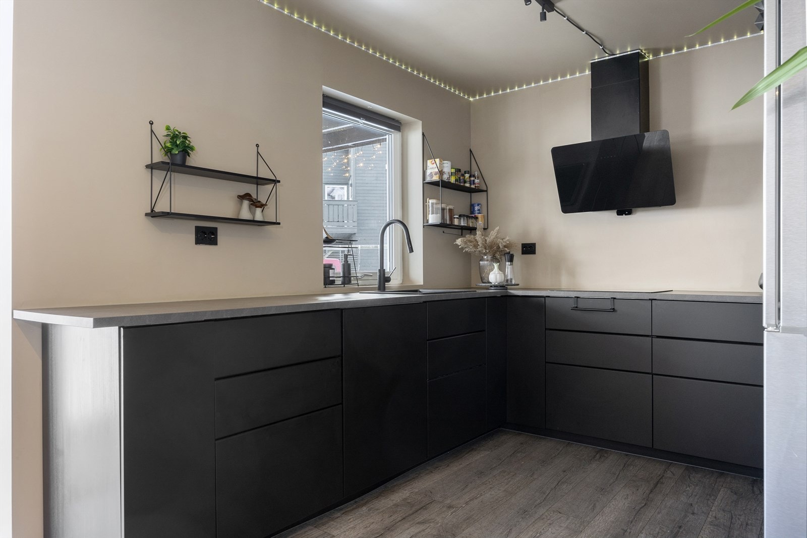 Kjøkkenet er moderne og stilrent med slette fronter og integrerte hvitevarer. Her har du rikelig med skap- og benkeplass, noe som gjør det enkelt å holde orden og tilberede mat i hverdagen. Galleribilde