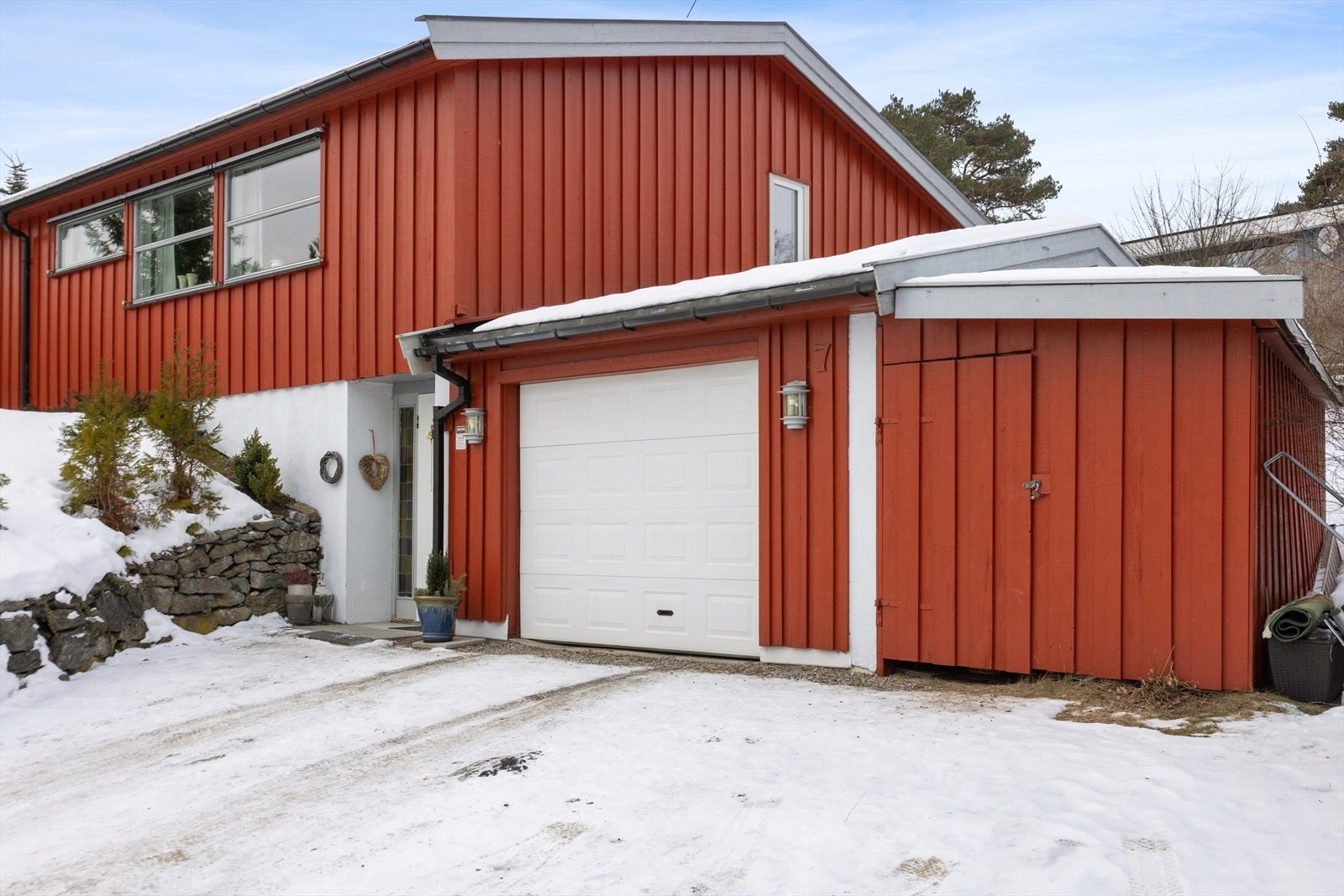 Til boligen hører en garasje med elektrisk portåpner og et tilhørende vedskjul. Galleribilde