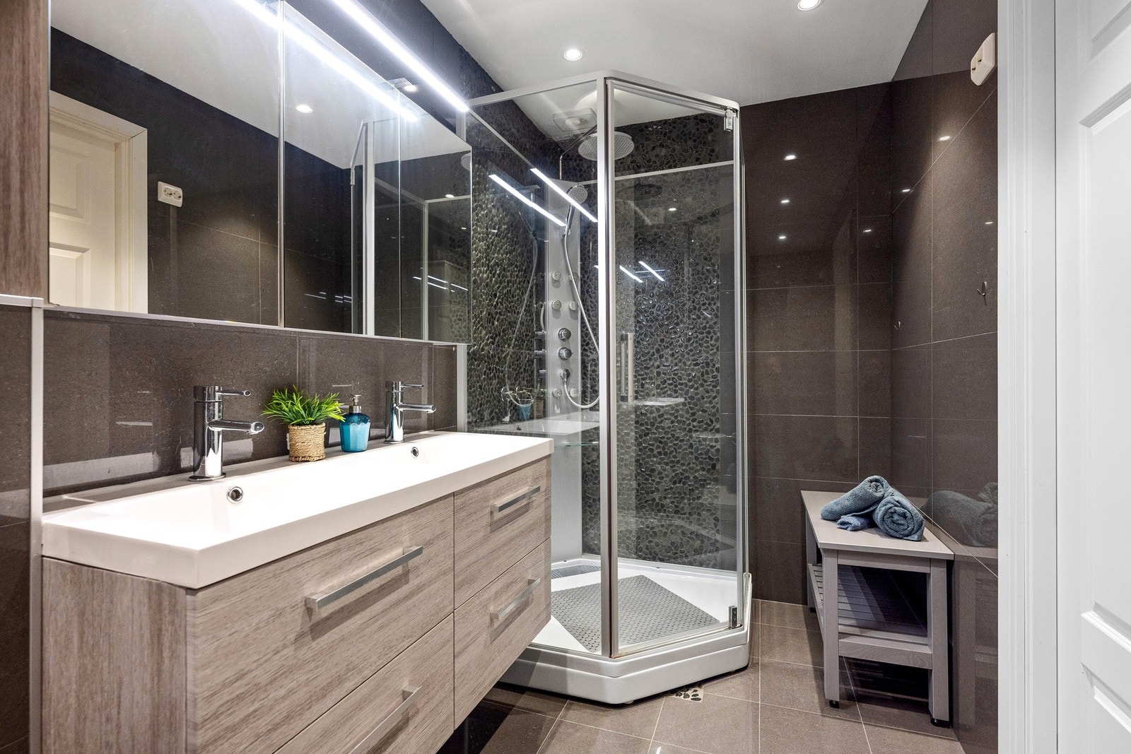 Også dette badet er innredet med vegghengt toalett, innredning med dobbel servant og dusjkabinett. Galleribilde