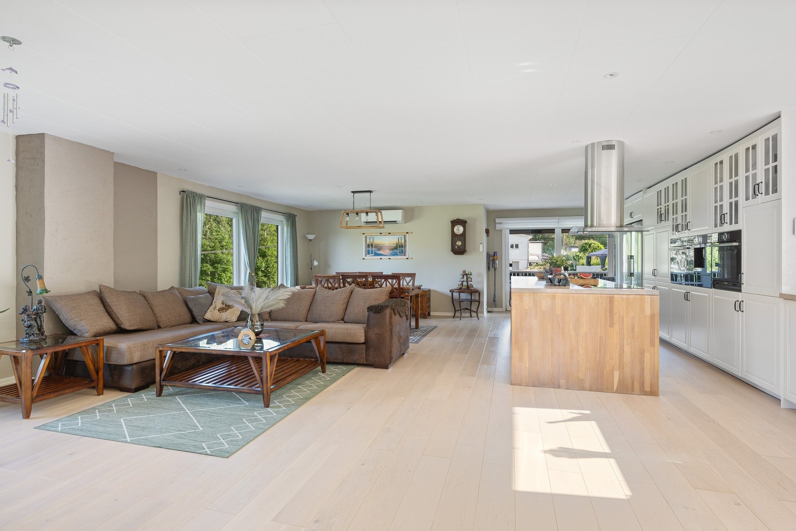 Store deler av 1. etasje består av en åpen og luftig sone med stue, spisestue og kjøkken. Galleribilde