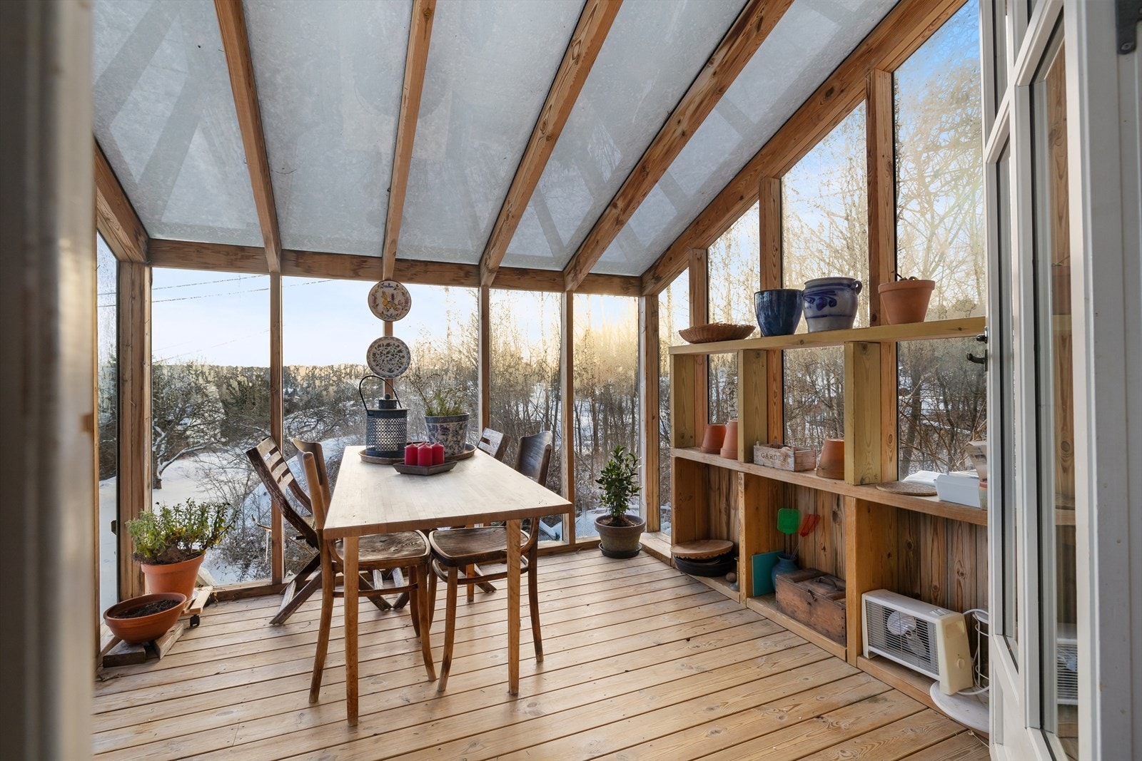 Lyst drivhus med store vindusflater gir utsikt mot vinterlandskapet. Galleribilde