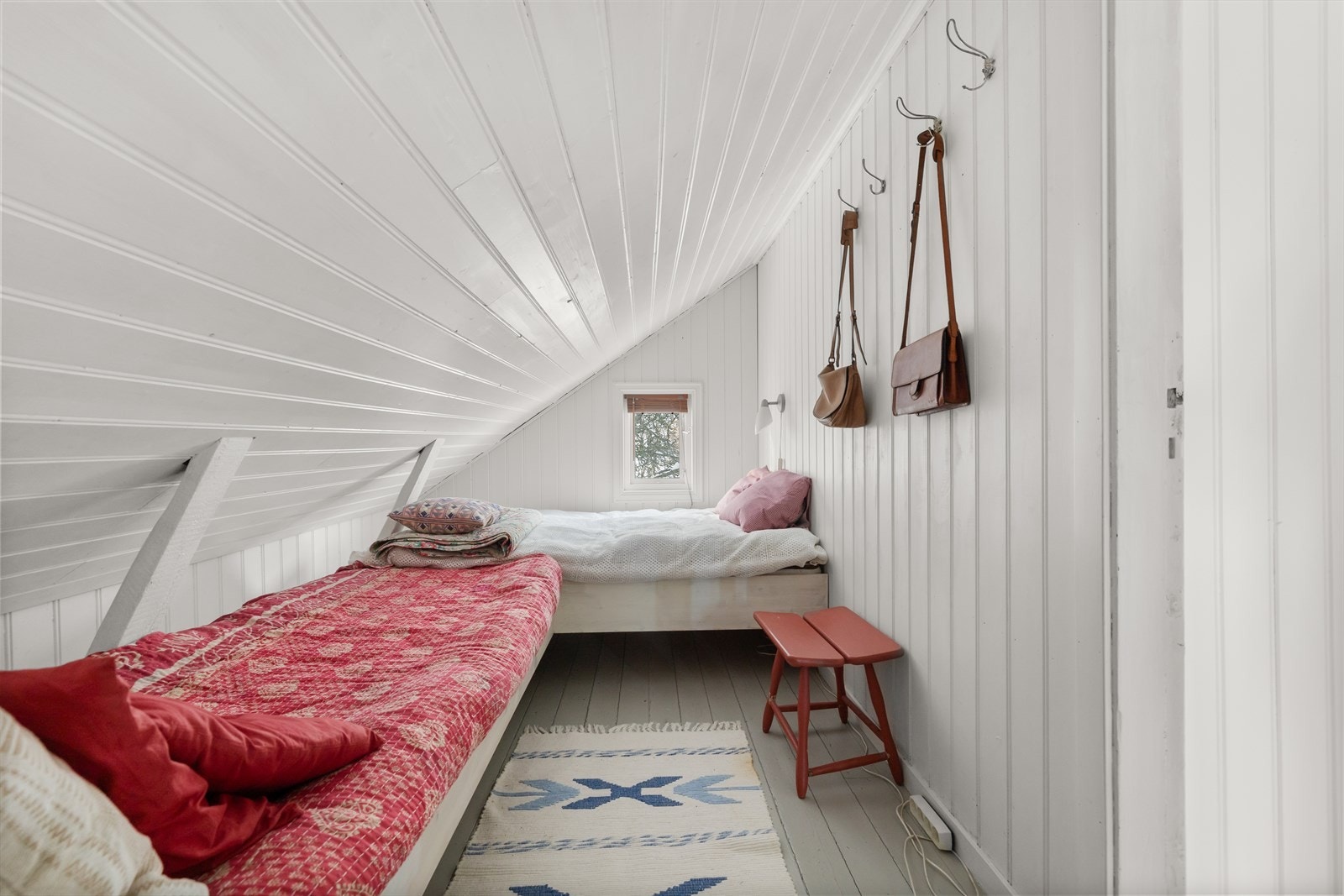 Hvite panelvegger og skråtak gir rommet en koselig loftsfølelse. Galleribilde