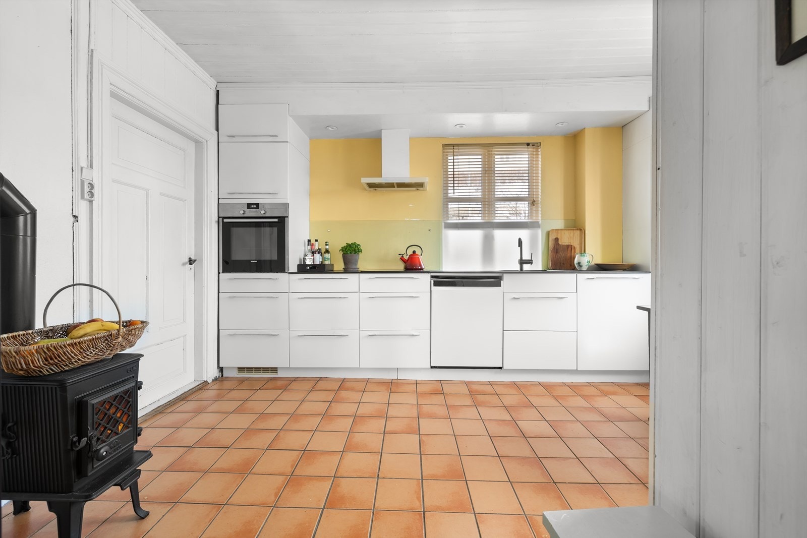 Hvite fronter og moderne innredning gir et stilrent kjøkkenmiljø. Galleribilde