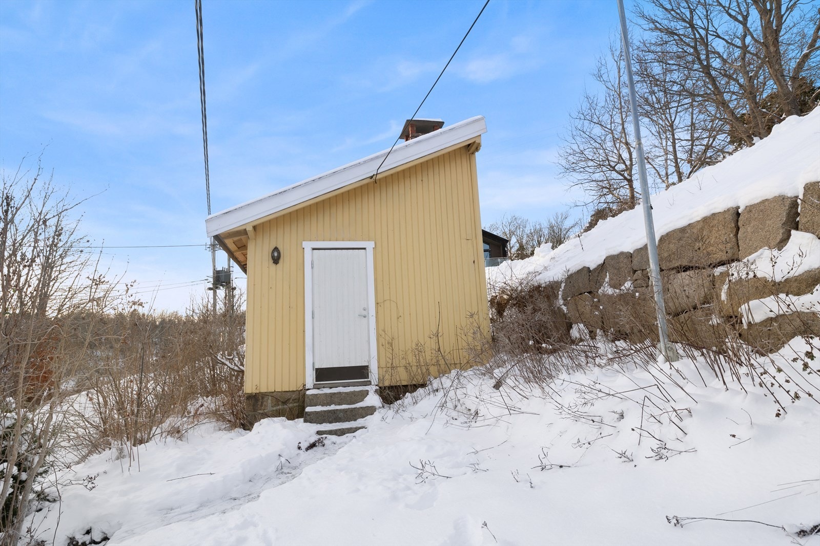 Utvendig panel i tre gir bygningen et tradisjonelt uttrykk, med enkel tilgang via trapp. Galleribilde