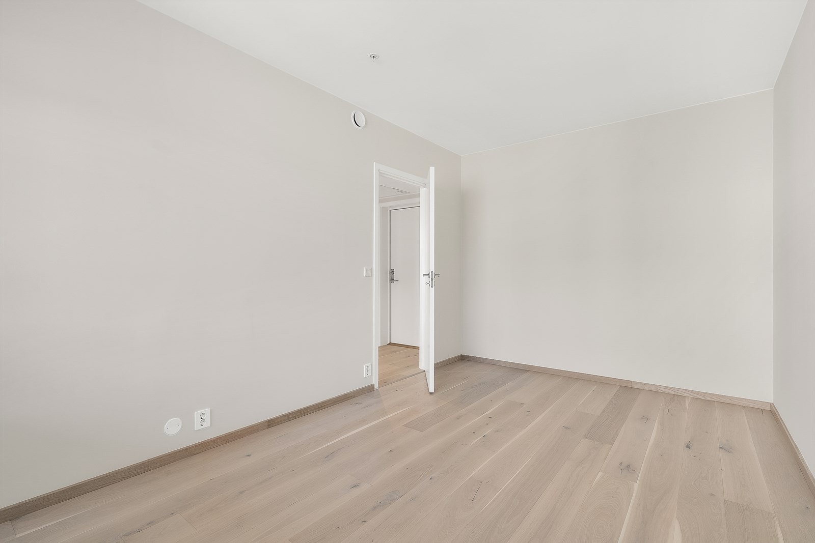 Lyst og romslig soverom med plass til en stor garderobe langs hele veggen for rikelig oppbevaring! Galleribilde