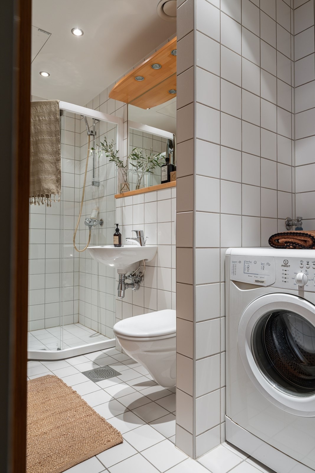 Badet er innredet med servant, speil med integrert belysning, vegghengt toalett med innebygd sisterne samt dusjsone med dusjdører i glass. Galleribilde