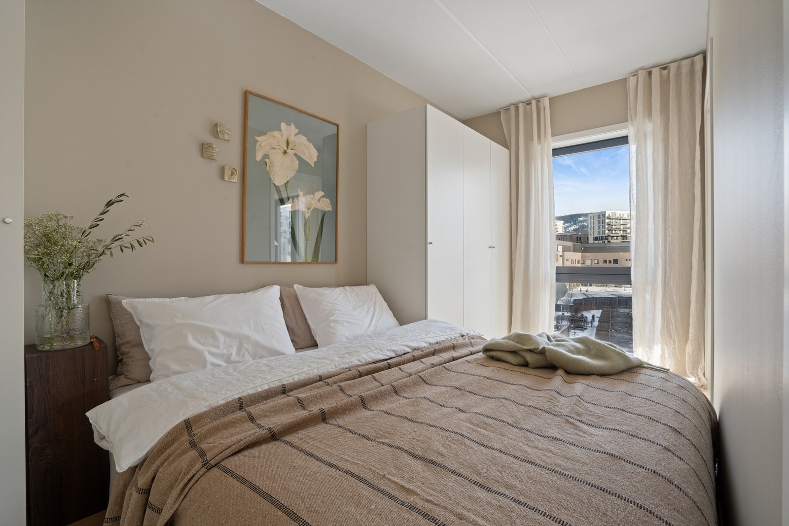 Lyst og innbydende soverom med plass til dobbeltseng og annet ønsket møblement. Soverommet har lyse overflater og en gjennomgående moderne stil. Galleribilde