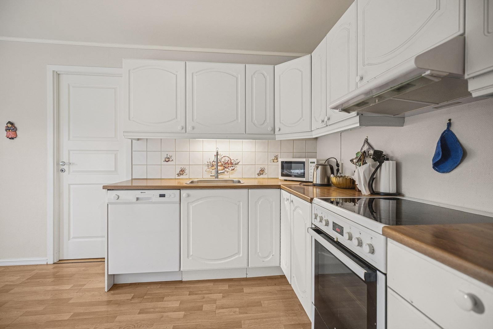 Praktisk kjøkken med profilerte fronter og laminerte benkeplater. Galleribilde