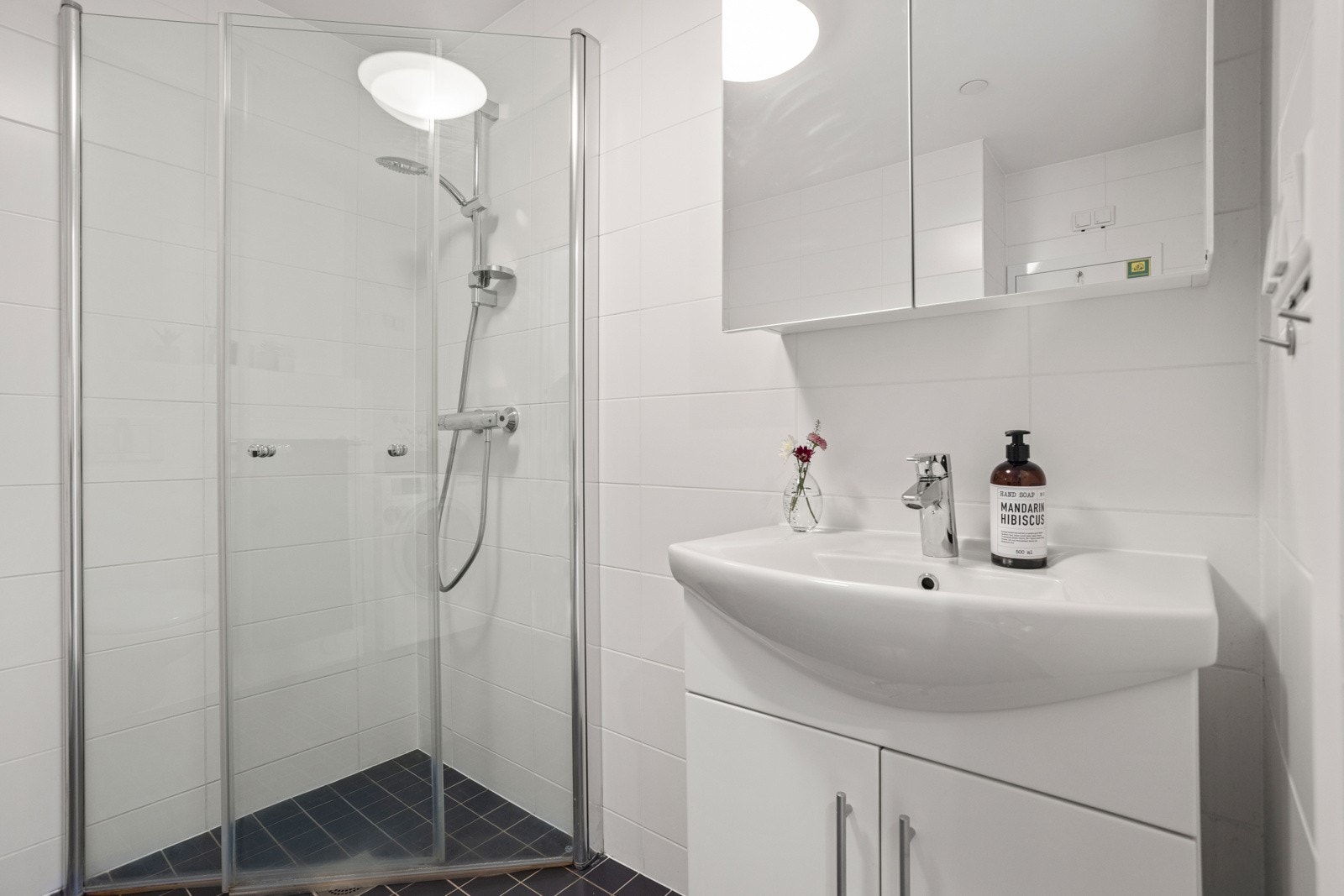 Badet har gulvvarme, vegghengt toalett, opplegg for vaskemaskin og et dusjhjørne med innfellbare glassdører Galleribilde