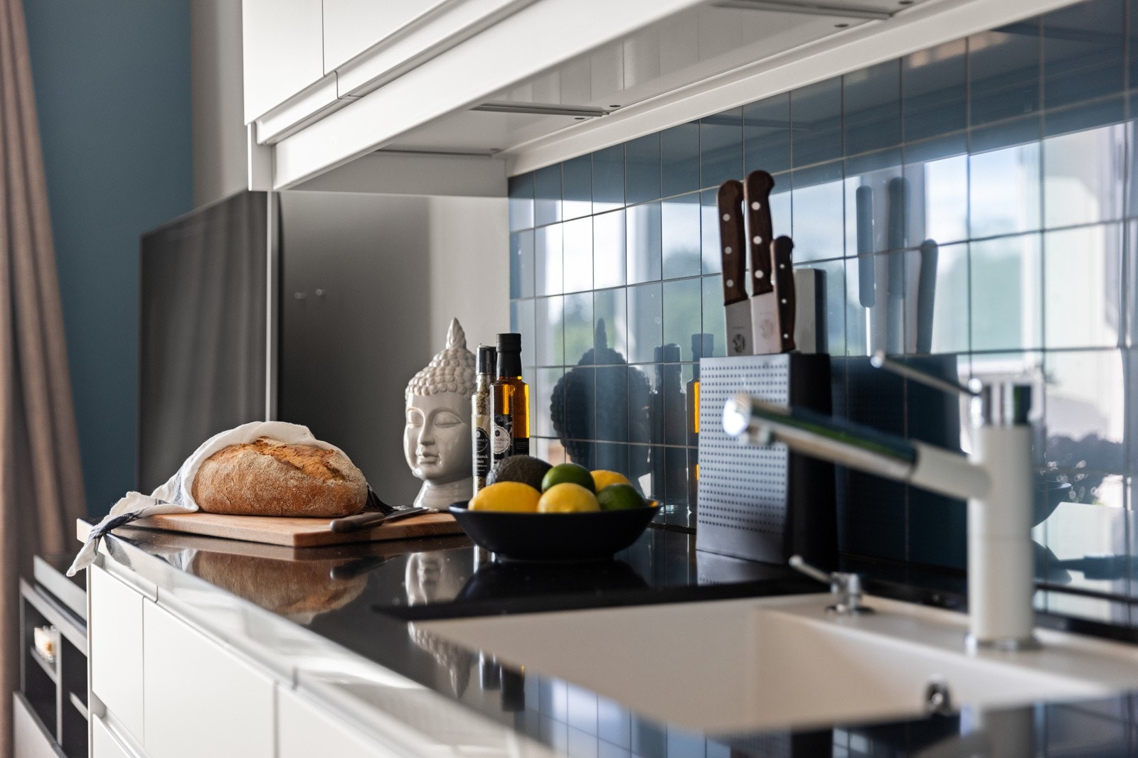 Veggene over benken er kledd med blå fliser, og under overskapene er det montert god arbeidsbelysning Galleribilde