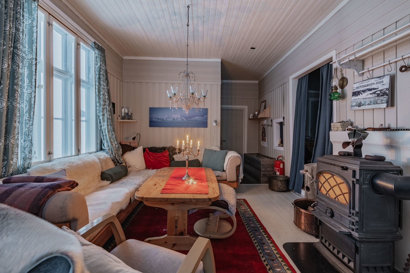 Stua er lun og koselig med vedfyring sentralt i rommet Galleribilde