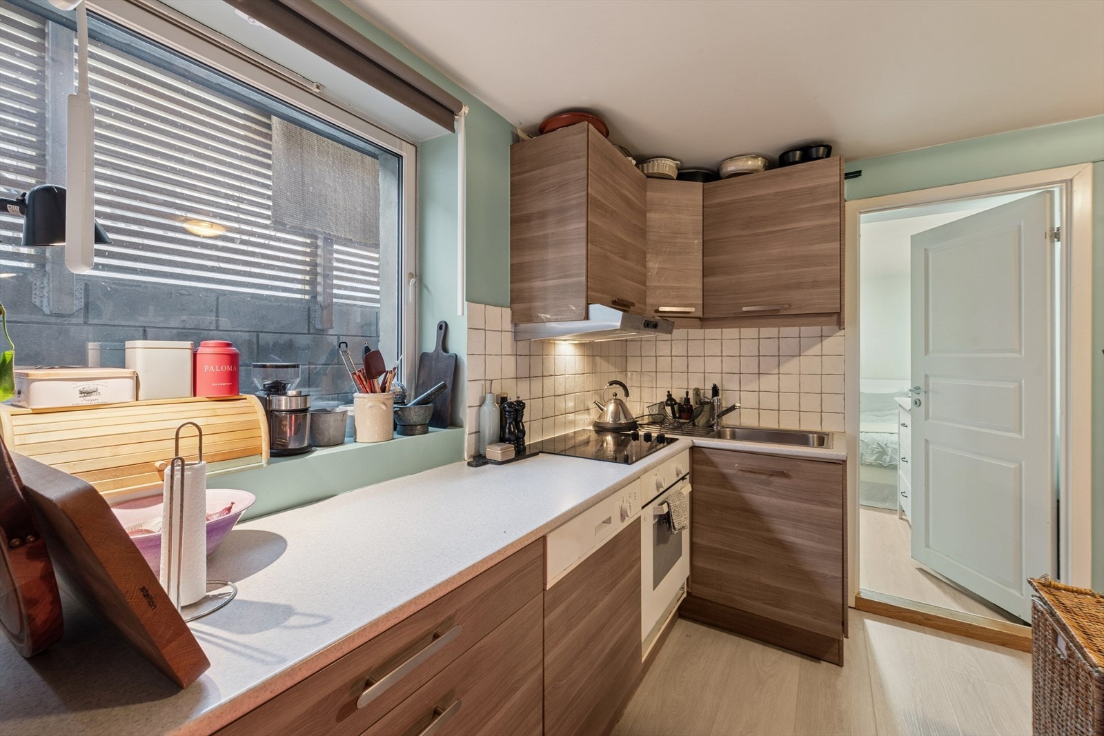 Innredningen har glatte fronter og en benkeplate med oppvaskkum, avrenningsfelt og kjøkkenkran. Galleribilde