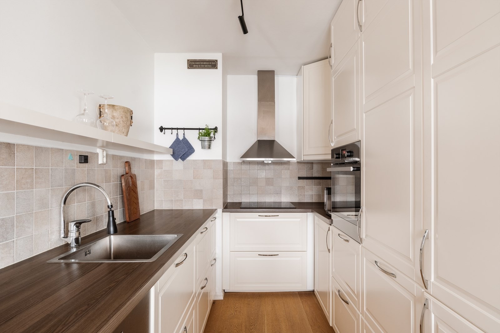 Kjøkkenet har en åpen løsning mot stuen, med profilerte fronter og integrerte hvitevarer. Galleribilde