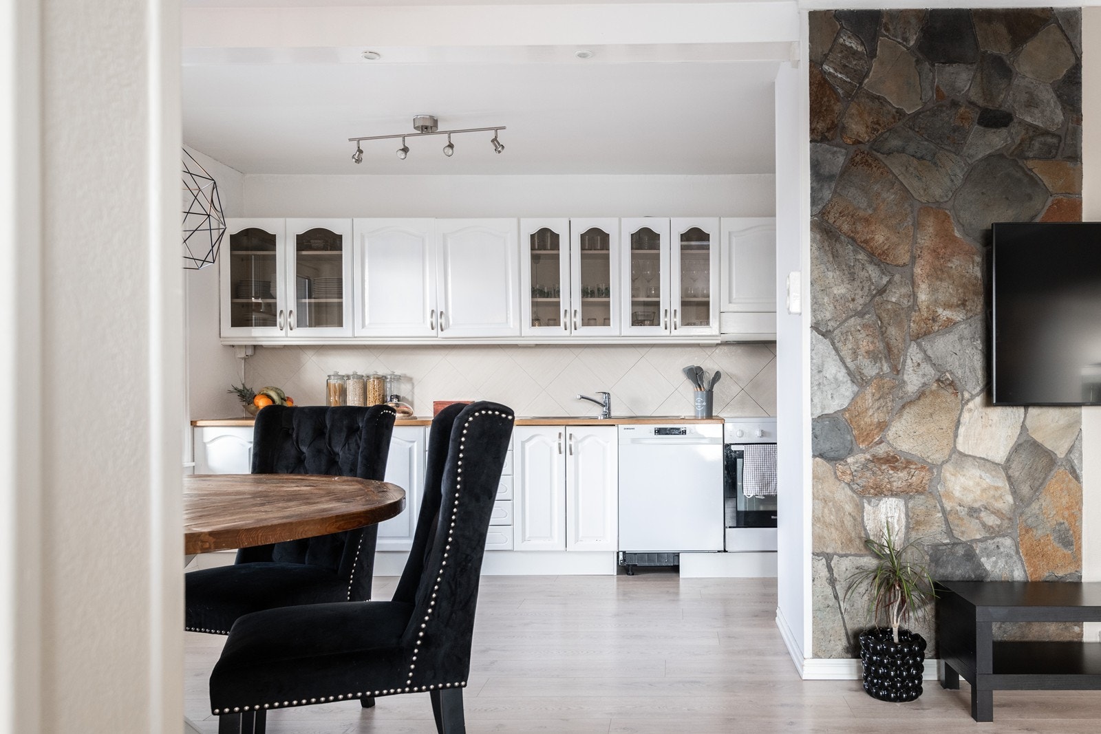 Kjøkkenet har hvite fronter med glassdetaljer og en laminert benkeplate. Galleribilde