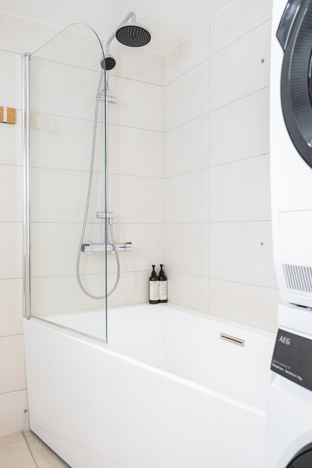 Dusjløsning i badekaret med en praktisk glassvegg. Galleribilde