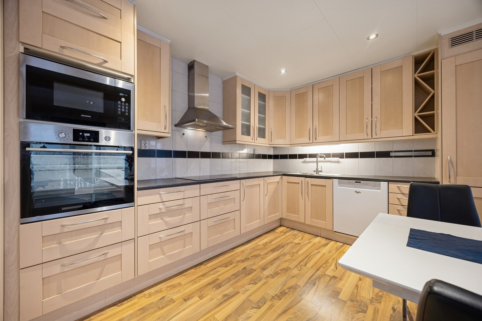 Kjøkkeninnredningen fra 2006 har profilerte fronter, laminat benkeplate og integrert oppvaskmaskin. Galleribilde