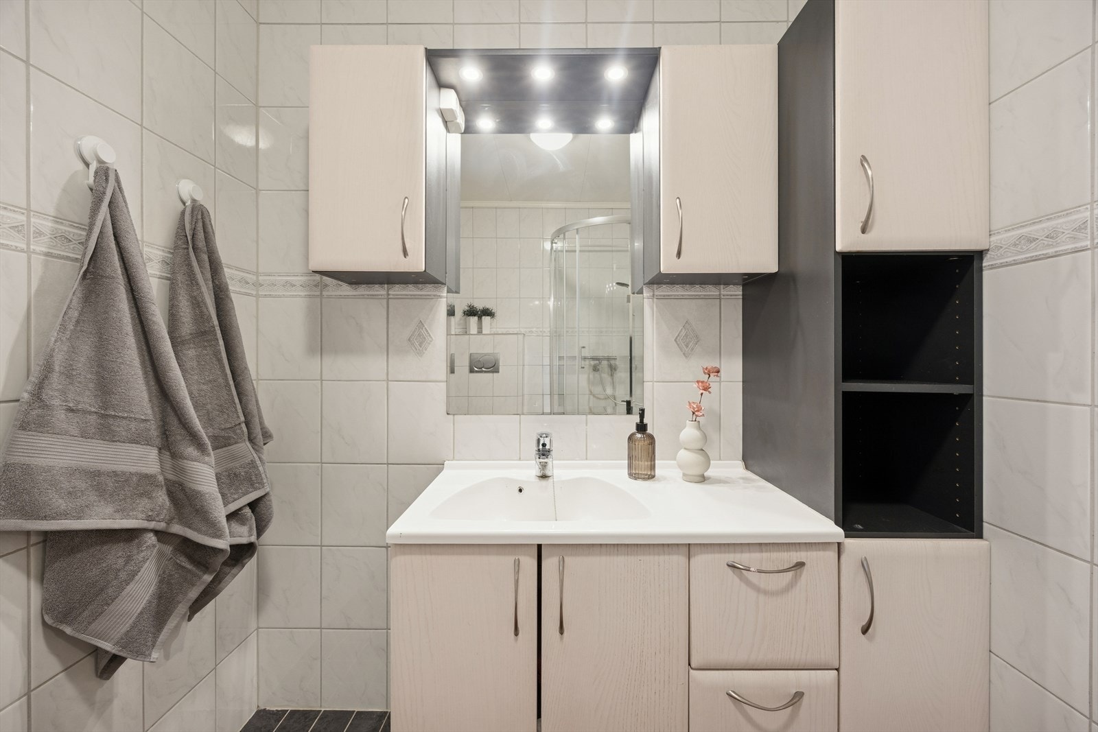 Praktisk baderomsinnredning med nedfelt servant og rikelig med oppbevaringsplass. Galleribilde