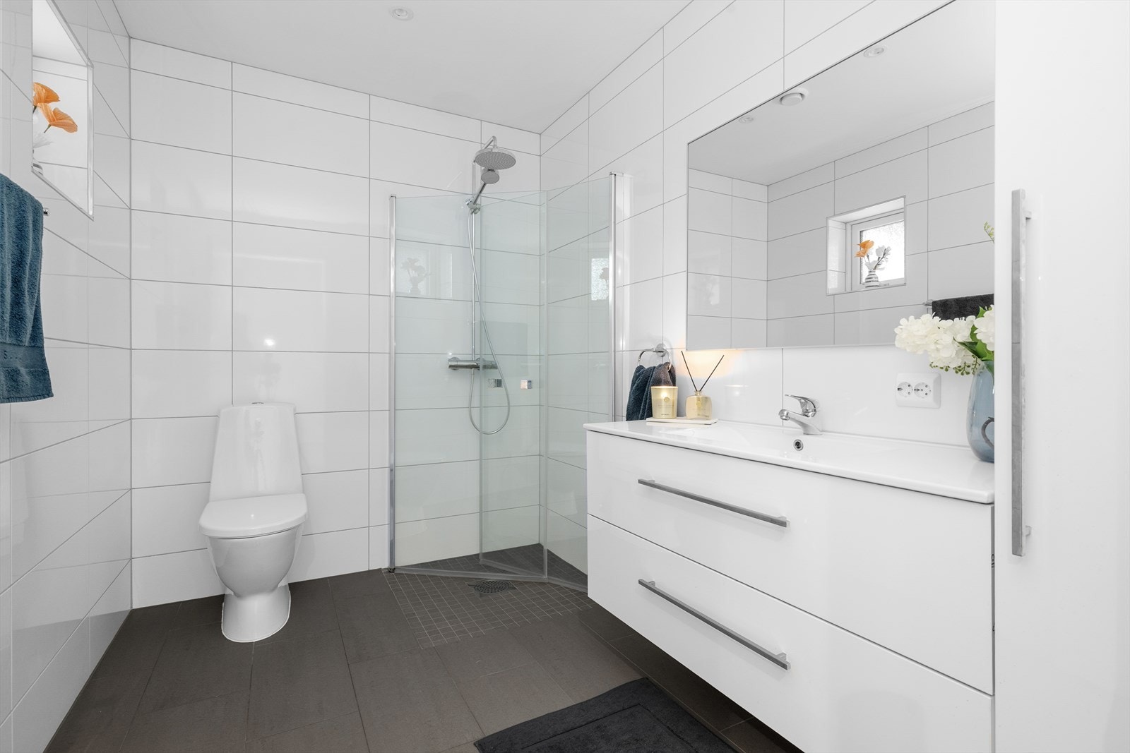 Baderommet i 1. etasje er lyst og delikat med flis på gulv med varmekabler, flis på vegg og malte plater i himling med spotter. Galleribilde