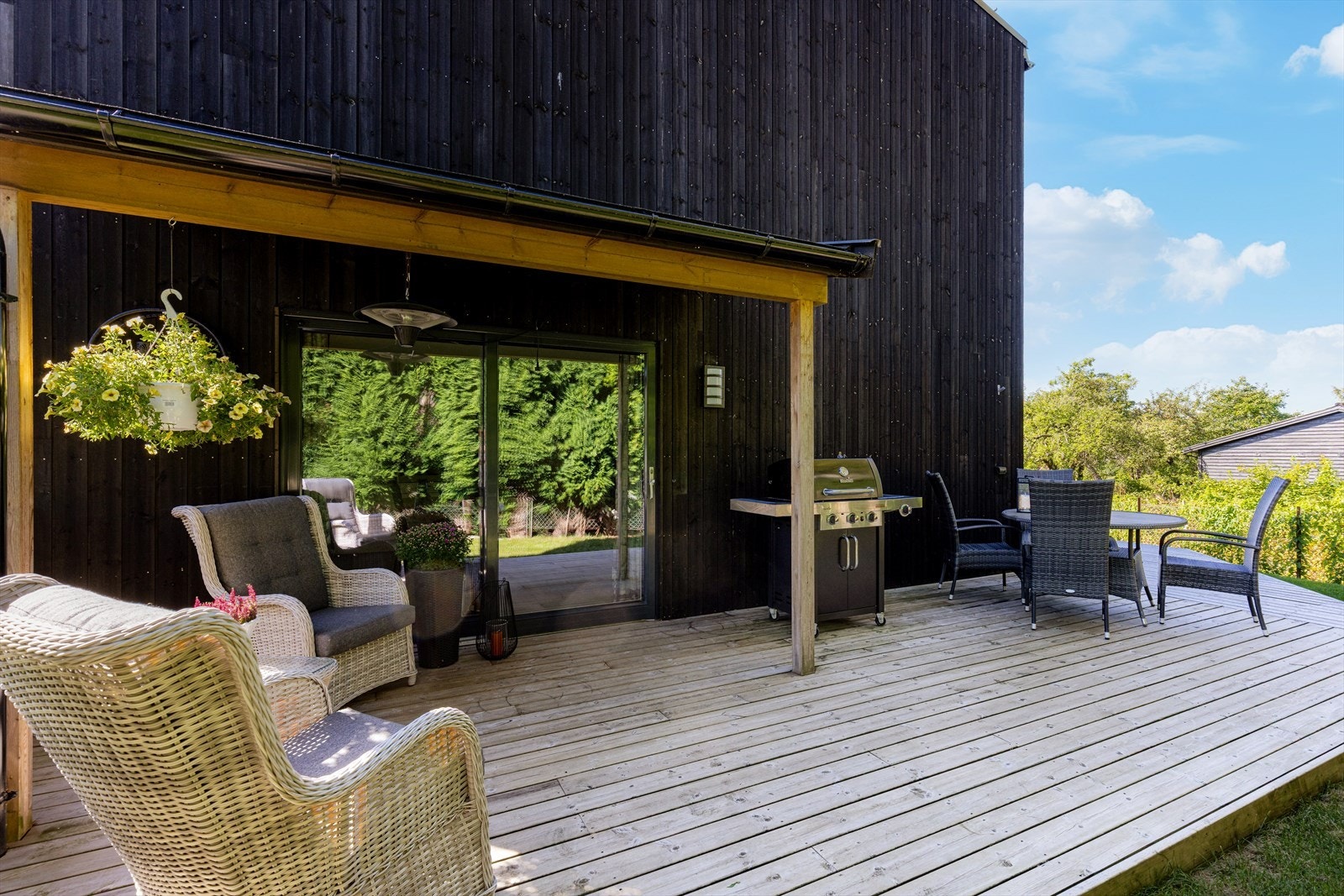 Terrassen ligger solrikt til og strekker seg rundt på baksiden av boligen. Galleribilde