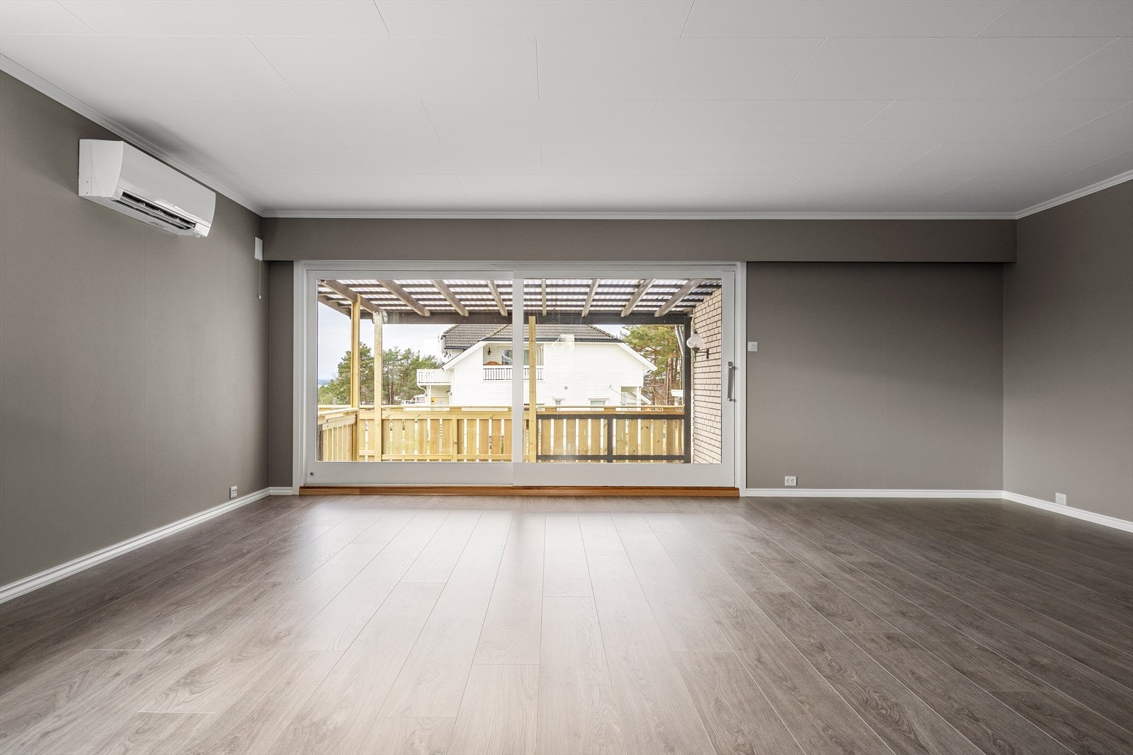 Boligens stue har store vindusflater og skyvedør mot vestvendt, overbygd terrasse gir flott lysinnslipp og en følelse av åpenhet. Galleribilde