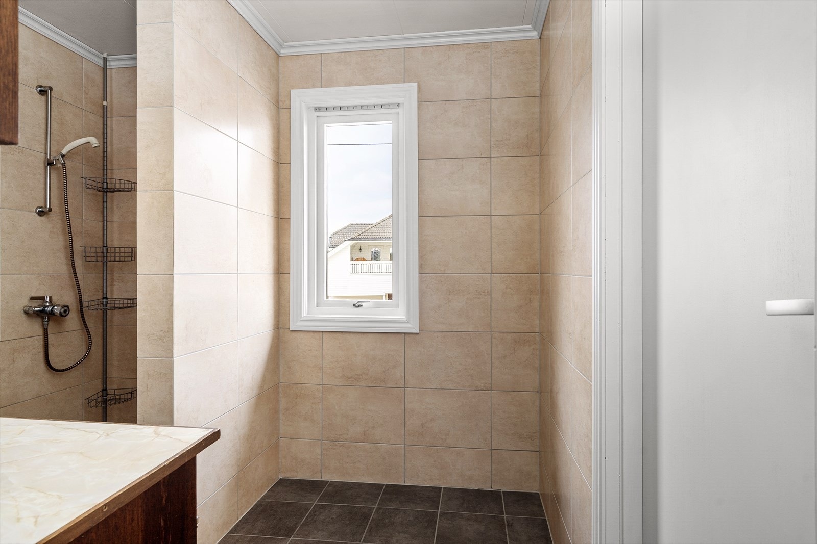 Dusjsonen ligger skjermet bak skillevegg og gir en praktisk og funksjonell rominndeling. Mørke gulvfliser med elektriske varmekabler sørger for god komfort. Galleribilde