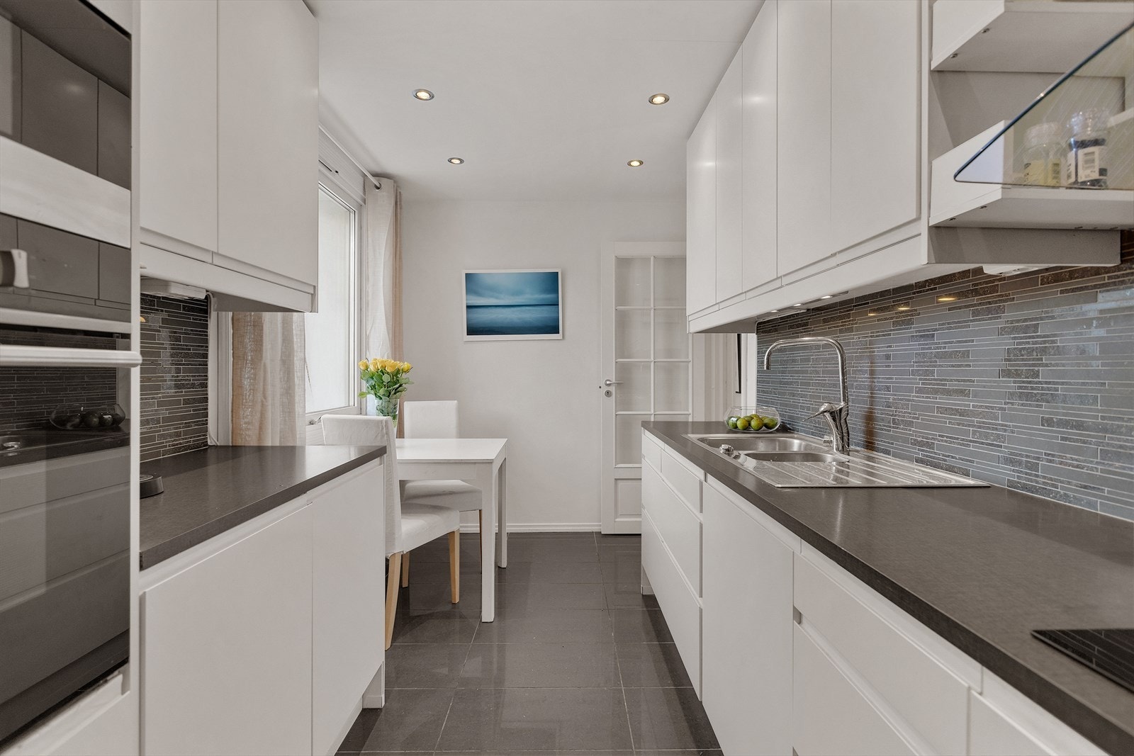 Moderne kjøkken med glatte, laminerte fronter i lys utførelse og laminert benkeplate. Galleribilde