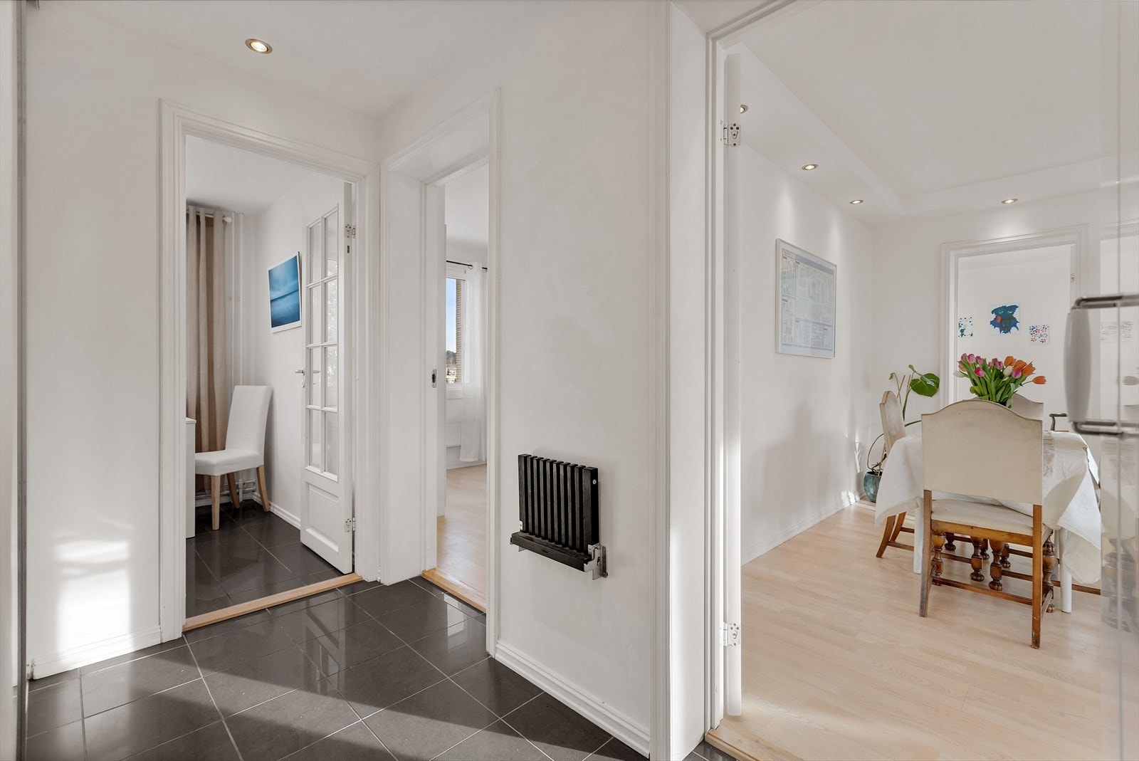 Romslig og innbydende entré med flislagt gulv og lyse vegger som gir et godt førsteinntrykk. Galleribilde