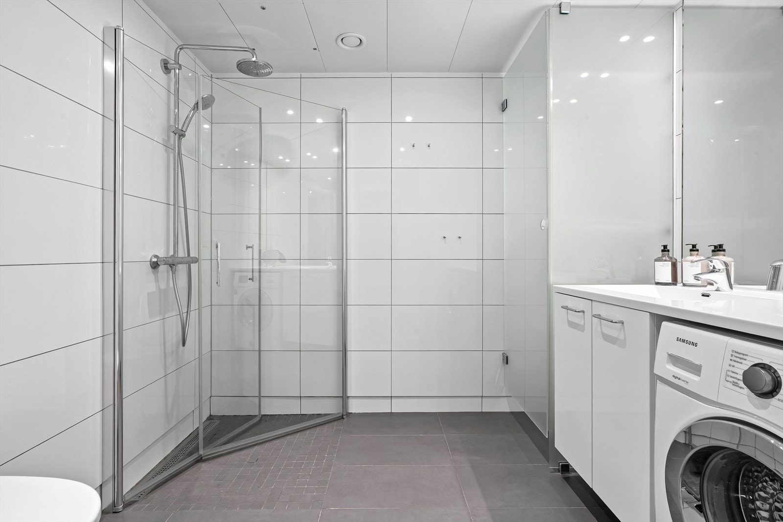 Delikat og innbydende bad med gulvvarme, downligths, tørkeskap og stor dusjsone. Plass til tørketrommel (riktig modell) nederst i tørkeskap ved behov Galleribilde