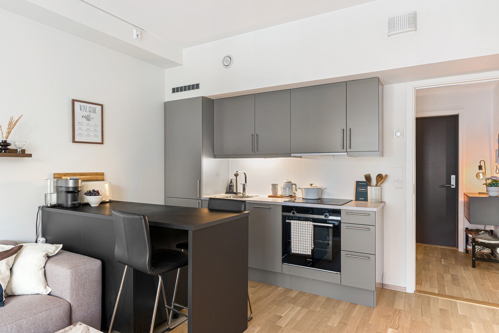 Kjøkkenet fremstår stilrent og påkostet, og kjøkkenøyen gir både ekstra lagringsplass og rikelig med benkeplass - perfekt for både hverdag og gjester. Galleribilde