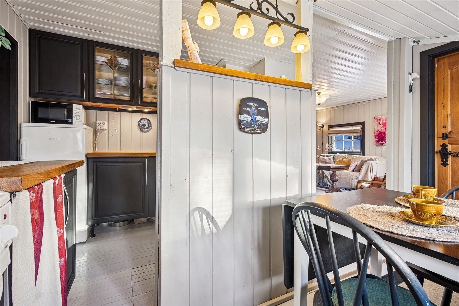 En delvis åpen løsning skiller kjøkkenet fra spiseplassen, men beholder den sosiale kontakten. Galleribilde