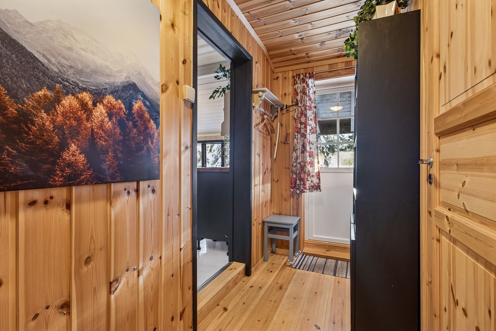 En gang med heltregulv leder videre inn til hyttas soveromsavdeling. Galleribilde