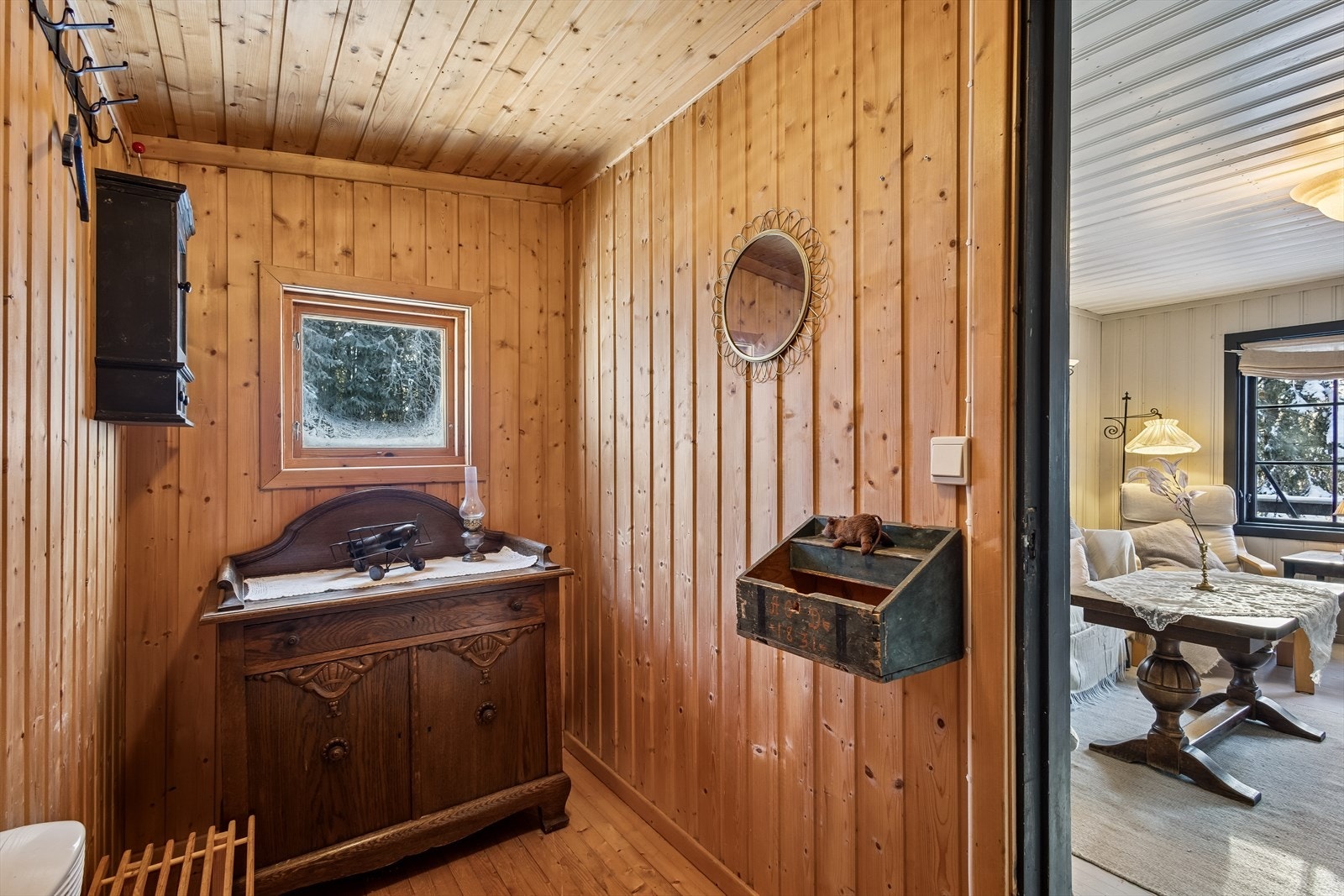 Velkommen inn i en tradisjonell entré med vegger og tak i ubehandlet trepanel. Galleribilde